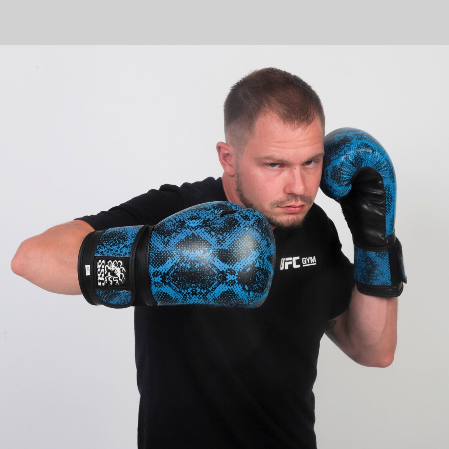 Boxer throwing a punch with Medusa’s Blue Gaze gloves – designed for bag work and sparring